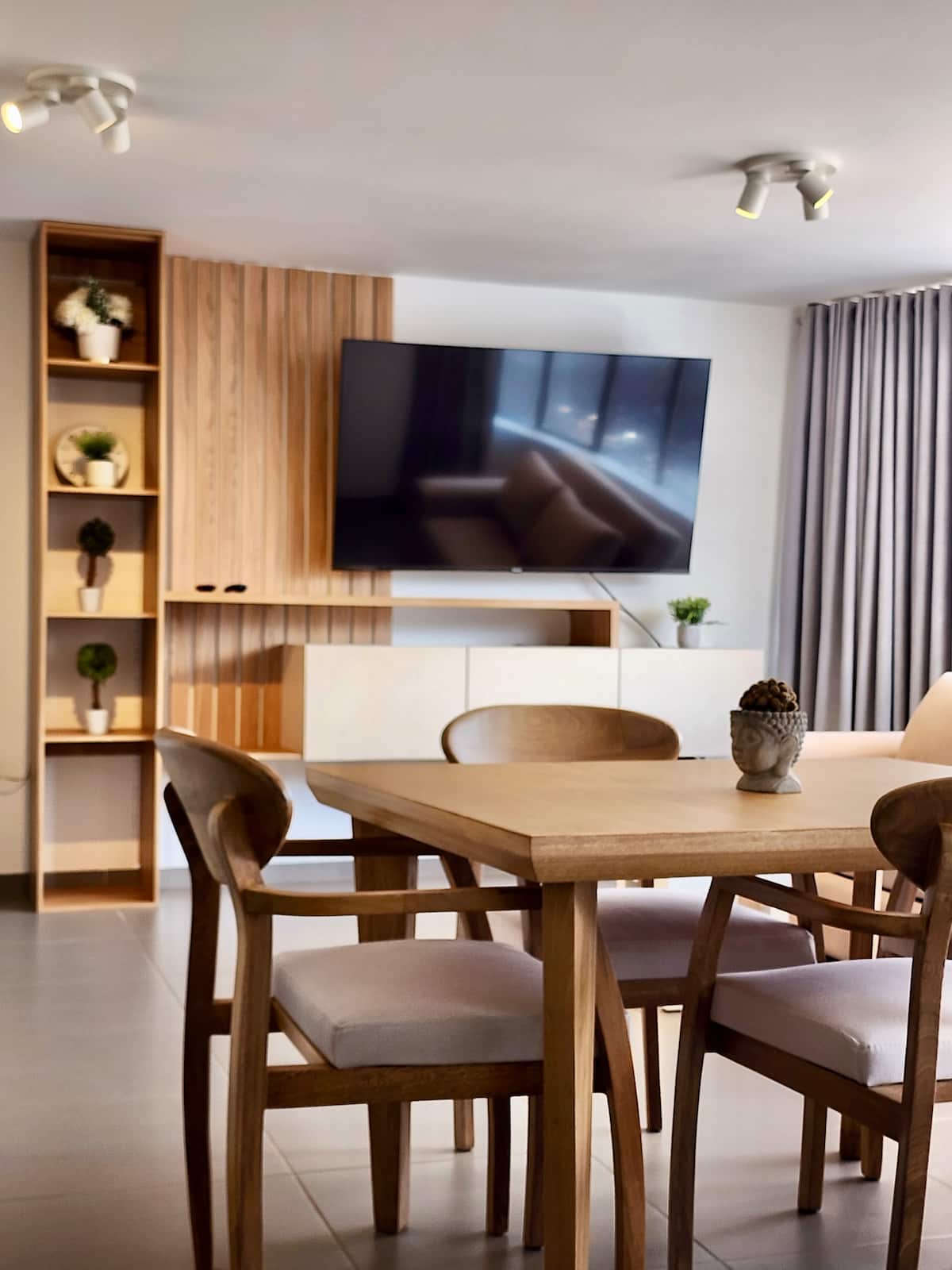 Comedor de madera para cuatro con televisor de pantalla plana y panel de listones
